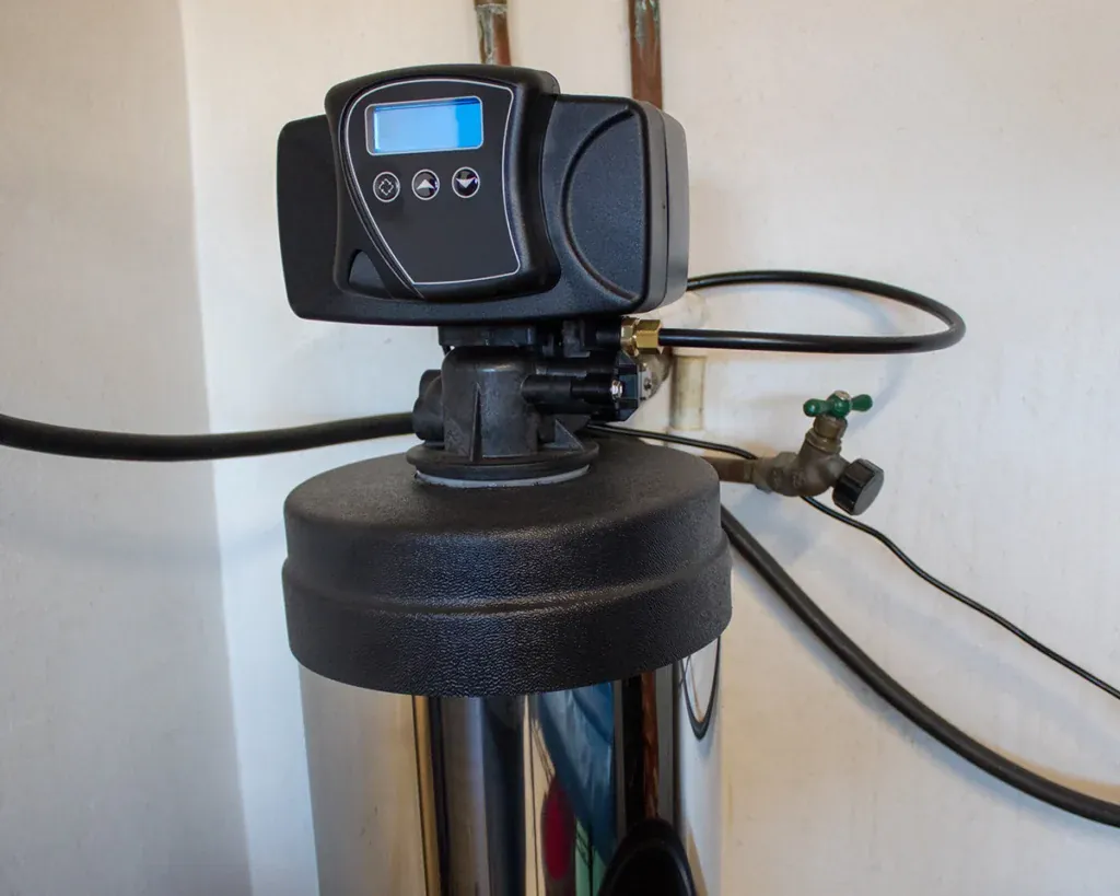 Water softener control head with a digital display mounted on the resin tank