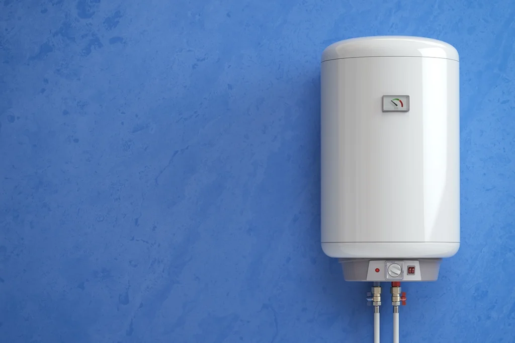 White wall-mounted electric water heater with a temperature gauge, hung on a blue wall with supply pipes below