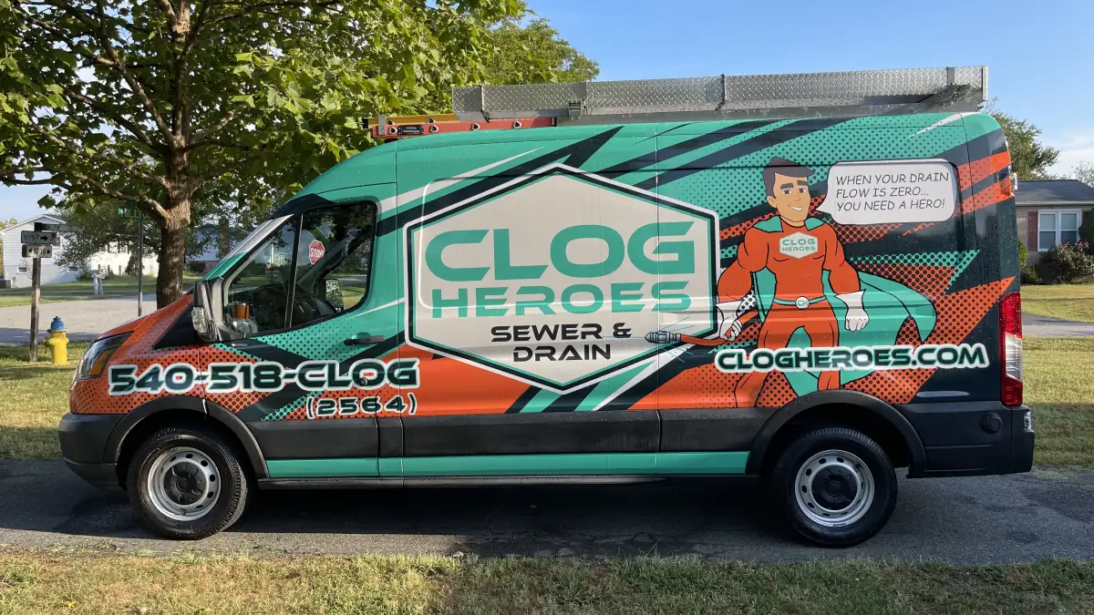 Wrapped Clog Heroes Transit van in full side profile on a residential street, showing the 540-518-CLOG number and Jetter Joe