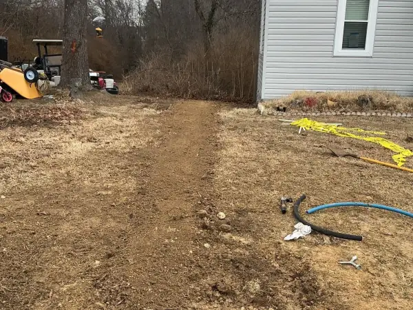 During: Water service trench with blue pipe near the house.