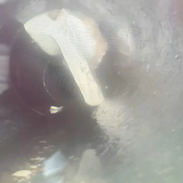 Drain camera view of an object lodged in the pipe.