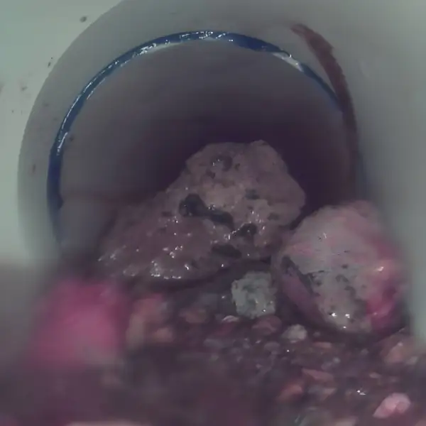 Sewer camera view of rocks blocking a PVC pipe.