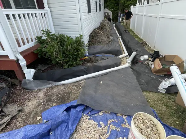 Before: Gravel bedding poured around the new sewer pipe in the side yard.