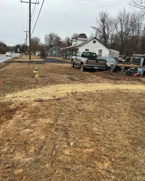 Backfilled water line trench running to the street.