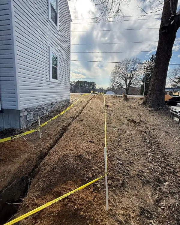 Long water service trench beside the house.