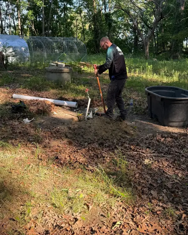 Technician repairing a well casing in the yard.