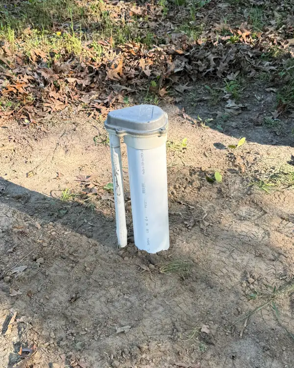 New well casing and cap installed in the yard.