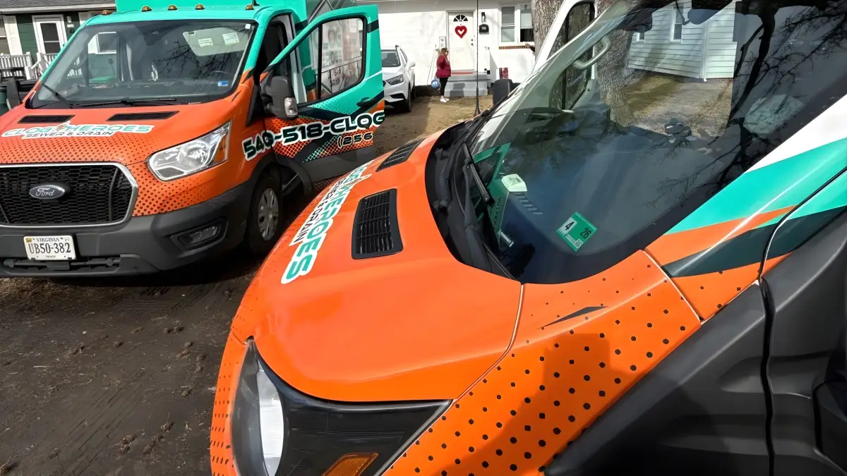 Close view of a Clog Heroes van's front fender graphic with a second van behind.